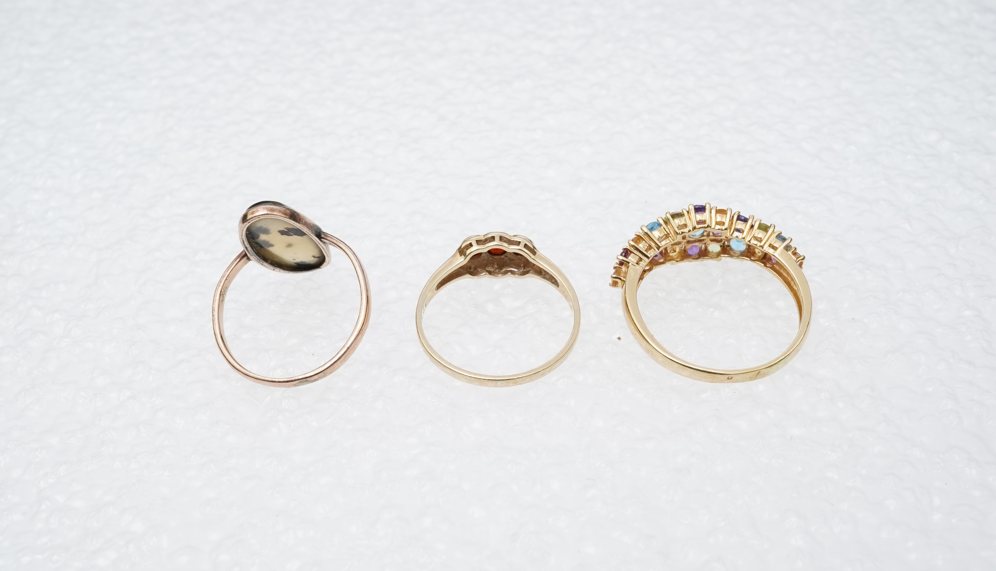 A modern 18ct gold and multi gem set cluster ring, size P, together with two 9ct rings including moss agate and a pair of 9ct gold and seed pearl set cabochon garnet ear studs.